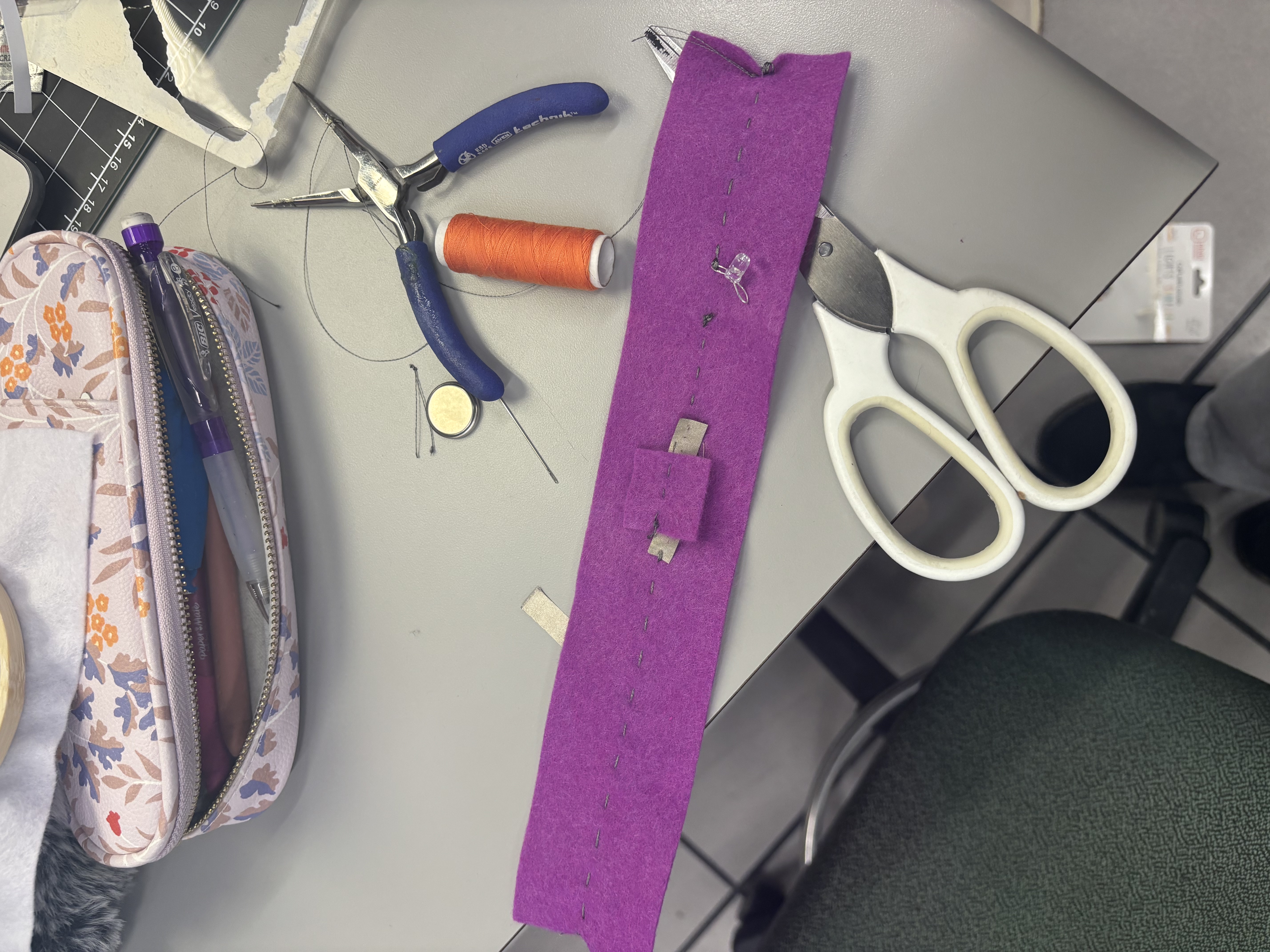 Attempt to make a batter pocket that is conductive using felt, conductive thread, conductive fabric, and a light bulb.