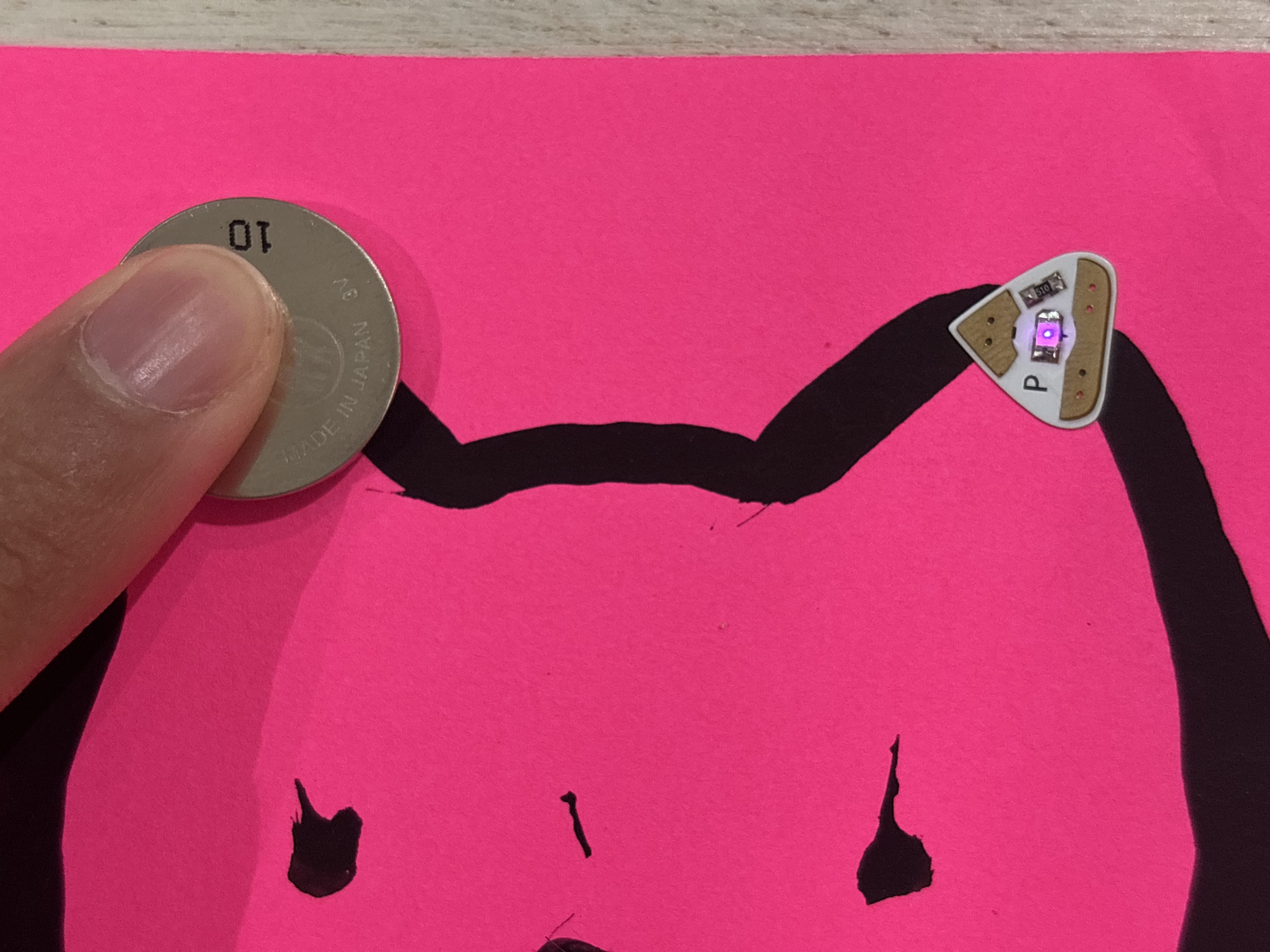 Paint circuit with conductive paint, a battery, and a light bulb.